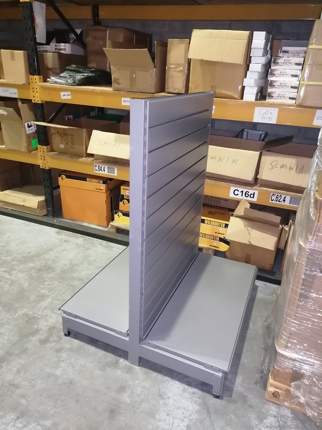 Double Sided grey shop shelving , 1350mm high. With slatwall